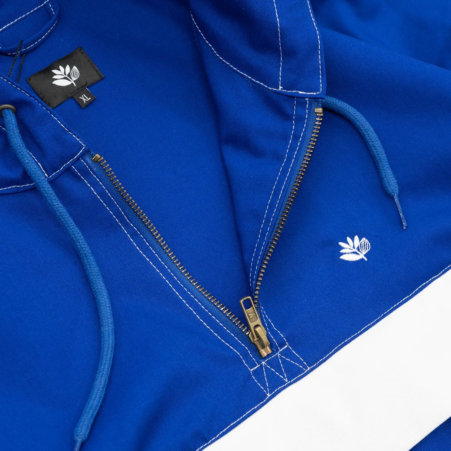 MAGENTA(マジェンタ)から待望の復刻を果たしたスケートの歴史に深く刻まれたTOM PENNYのあの伝説的アノラックジャケット「TOM 96 JACKET」のBLUEカラーの胸元ハーフジップの写真