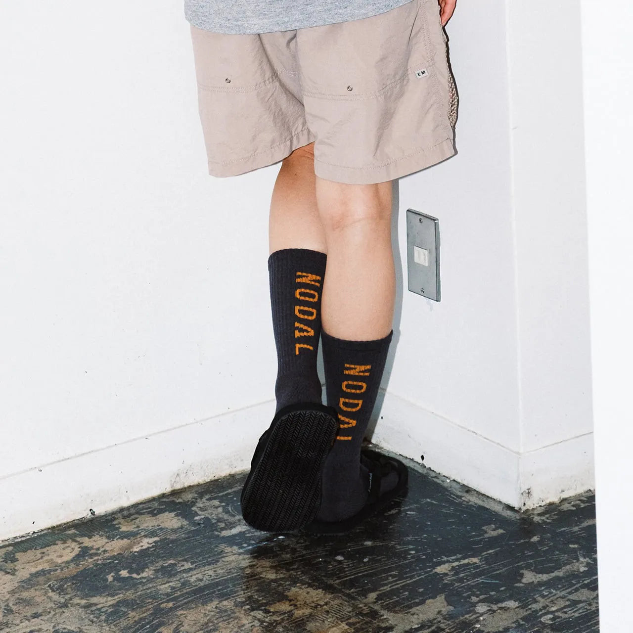 NODAL（ノーダル）ロゴを背面に配し存在感を放つソックス「LOGO SOCKS」のCHARCOAL&ORANGカラーの着用画像