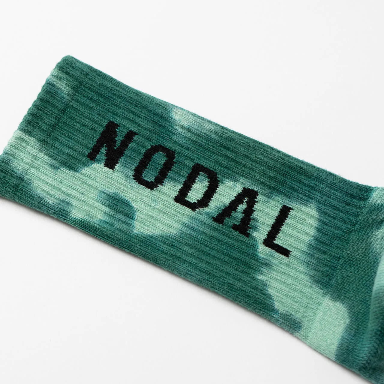 NODAL（ノーダル）の定番のLOGO SOCKSを職人の手染めでタイダイ加工したソックス「TIE DYE LOGO SOCKS」のGREENカラーの脛裏側のブランドロゴの写真