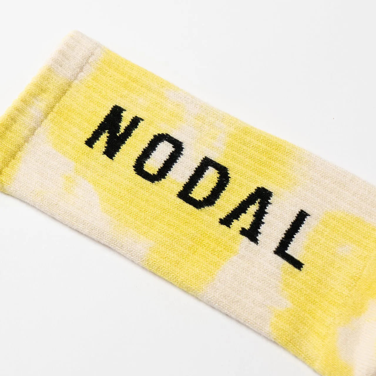 NODAL（ノーダル）の定番のLOGO SOCKSを職人の手染めでタイダイ加工したソックス「TIE DYE LOGO SOCKS」のYELLOWカラーの脛裏側のブランドロゴの写真