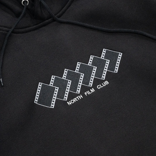 NORTH SKATE MAG(ノーススケートマグ)のフロントにデザインが刺繍で入る肉厚なパーカー「FILM CLUB HOODIE」のBLACKカラーの正面デザインの写真
