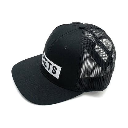 フロントにボックスロゴの刺繍がされたPOETS(ポエッツ)のトラッカーキャップ(メッシュキャップ)「LINCOLN TRUCKER CAP」のBLACKカラーの左斜め手前からの商品写真