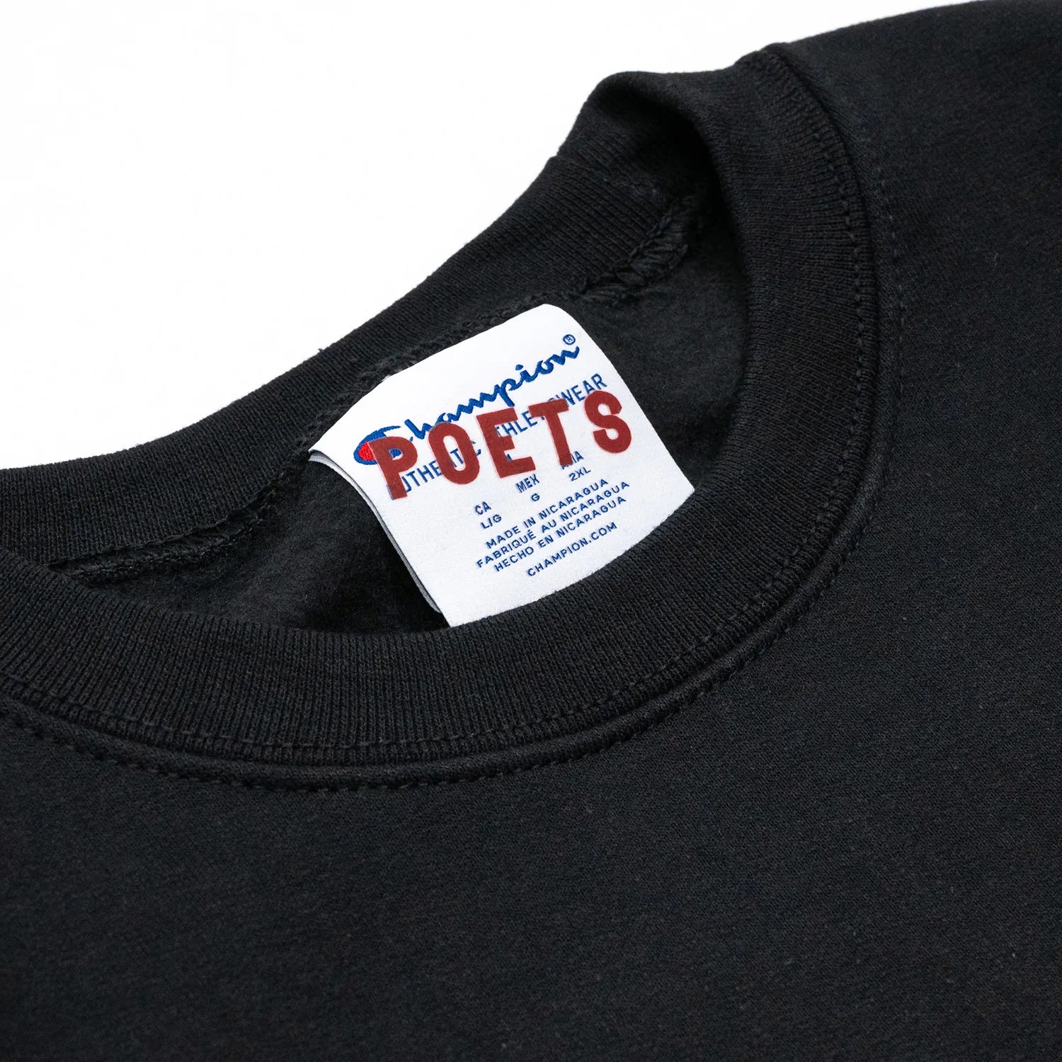 フロントにブランドロゴがフロッキープリントされたPOETS(ポエッツ)のスエット「OG FLOCKED CHAMPION CREW SWEAT」のBLACKカラーの襟元の写真