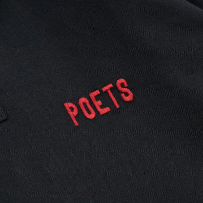 POETS(ポエッツ)の肉厚な生地を使用した2ボタンラガーシャツ「RUGBY WITH EMBROIDERED LOGO」のBLACKカラーの左胸のワンポイント刺繍デザインの写真