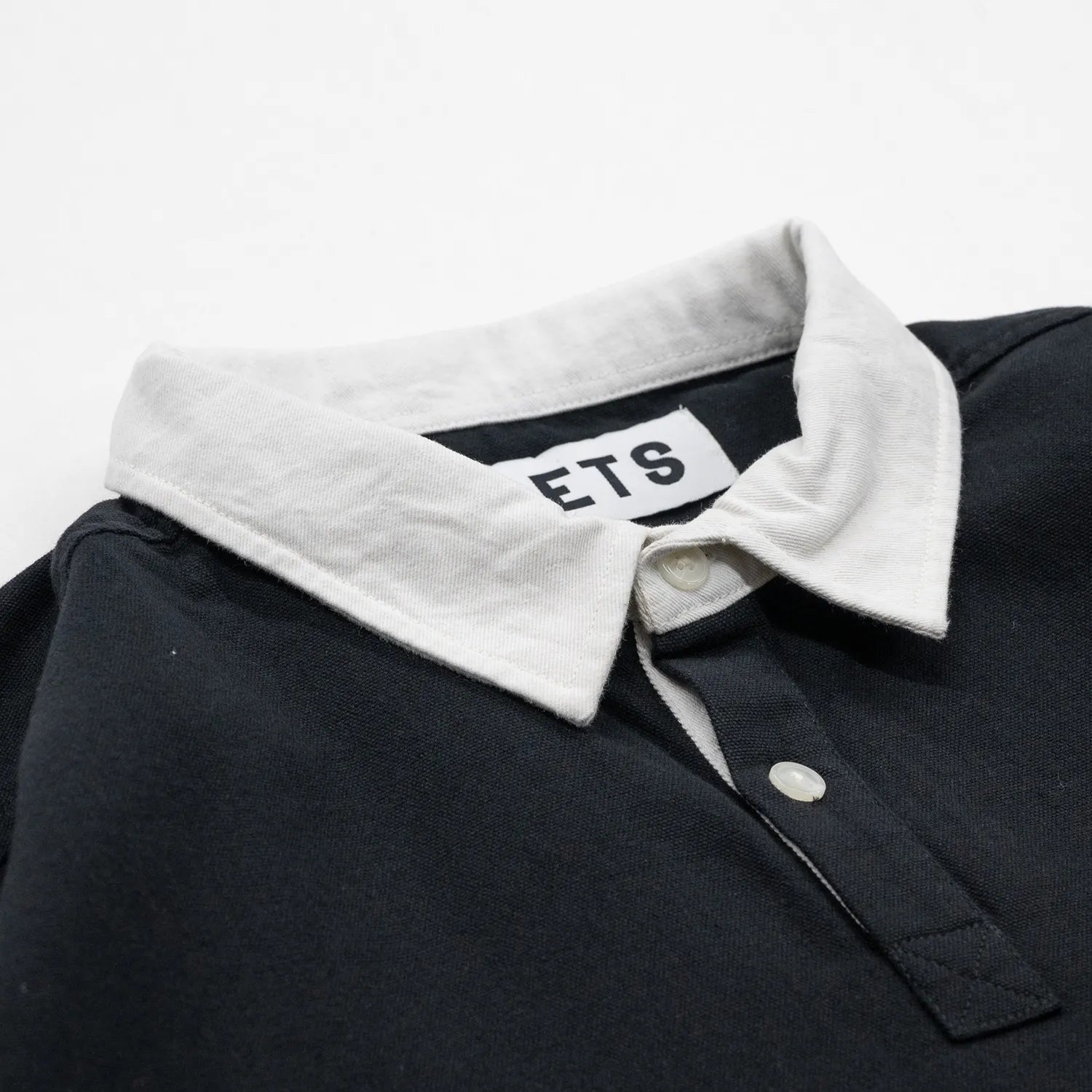 POETS(ポエッツ)の肉厚な生地を使用した2ボタンラガーシャツ「RUGBY WITH EMBROIDERED LOGO」のBLACKカラーの襟元の写真