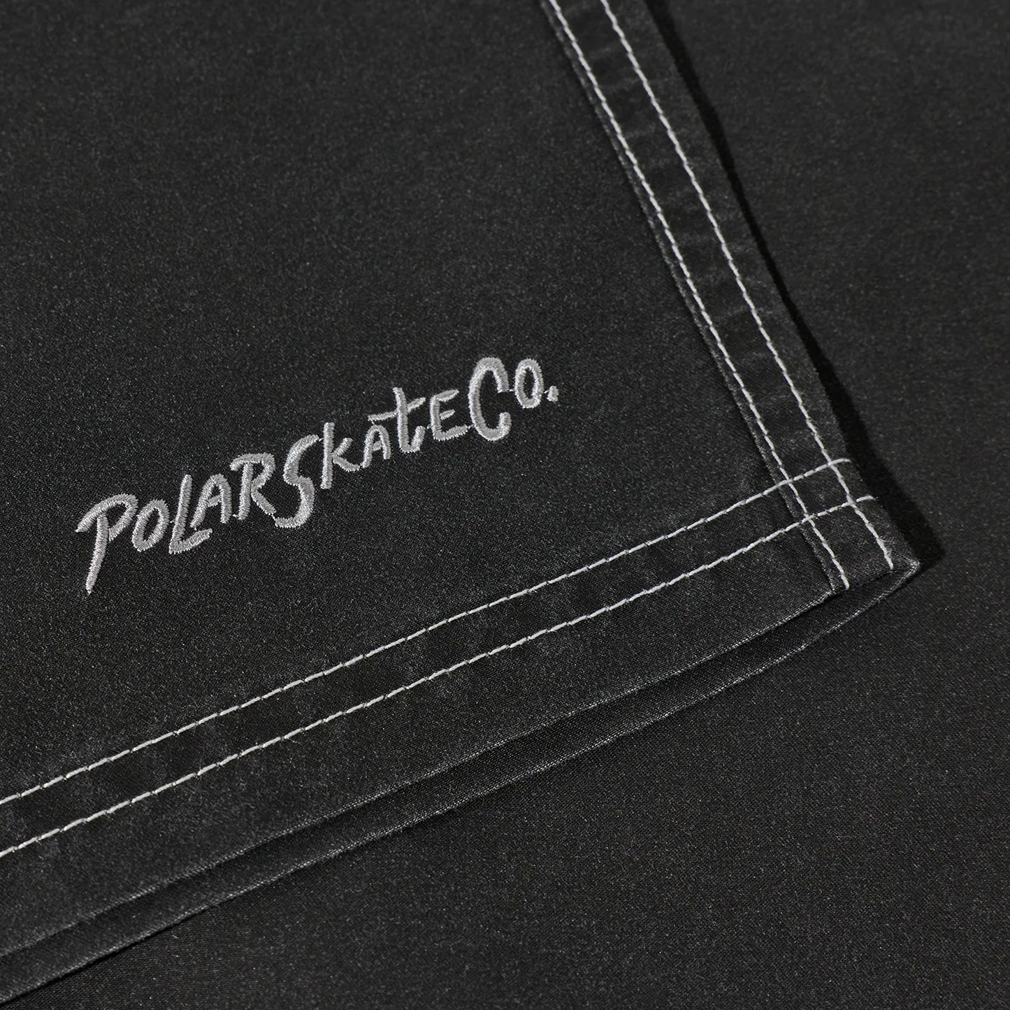 水陸両用可能なPolar Skate Co(ポーラー)のスイムショーツ「ZIGGY SWIM SHORTS」のVINTAGE BLACKカラーの裾の刺繍デザインの写真
