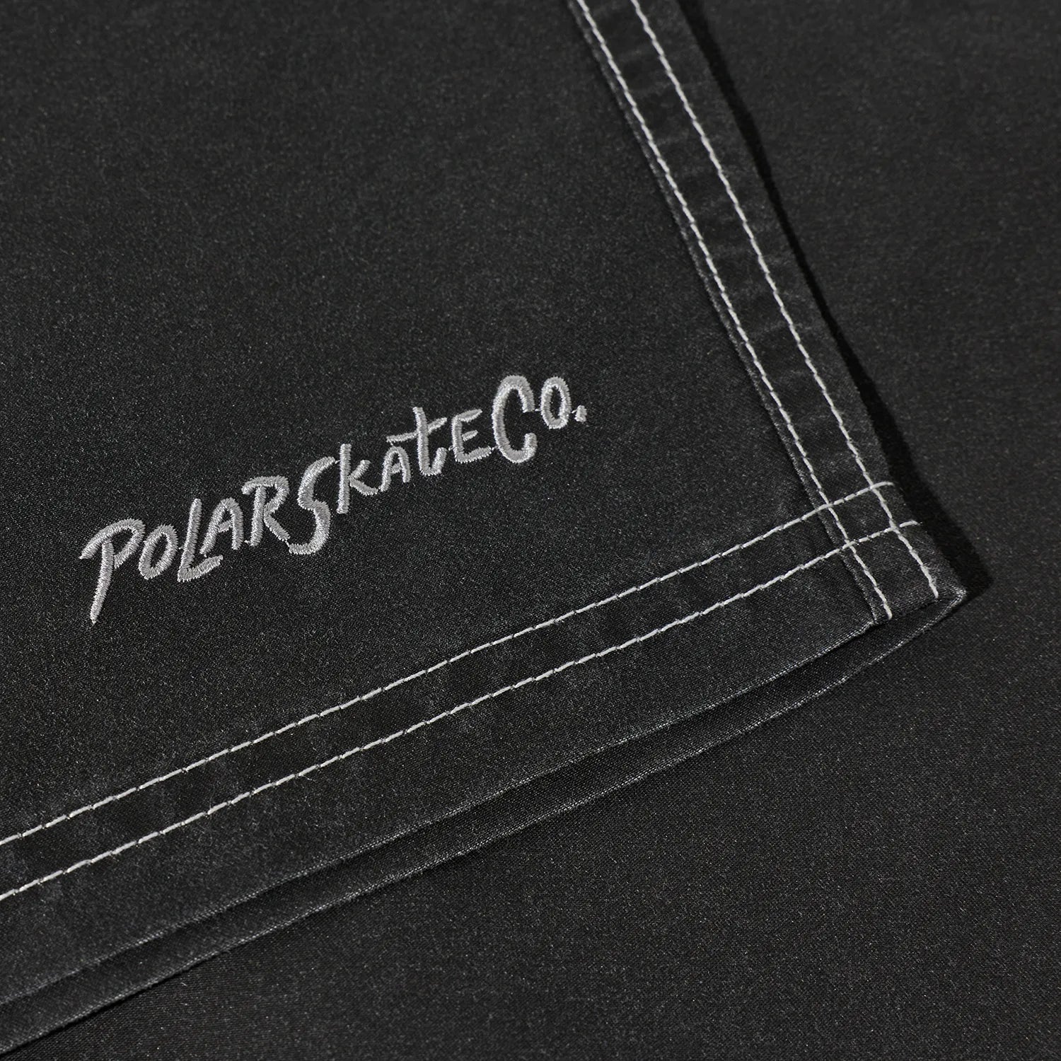 水陸両用可能なPolar Skate Co(ポーラー)のスイムショーツ「ZIGGY SWIM SHORTS」のVINTAGE BLACKカラーの裾の刺繍デザインの写真