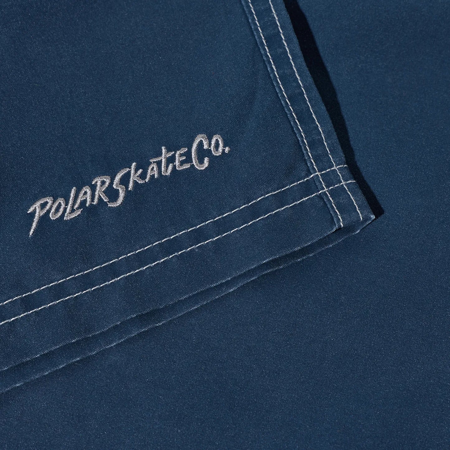 水陸両用可能なPolar Skate Co(ポーラー)のスイムショーツ「ZIGGY SWIM SHORTS」のVINTAGE INDIGOカラーの裾の刺繍デザインの写真