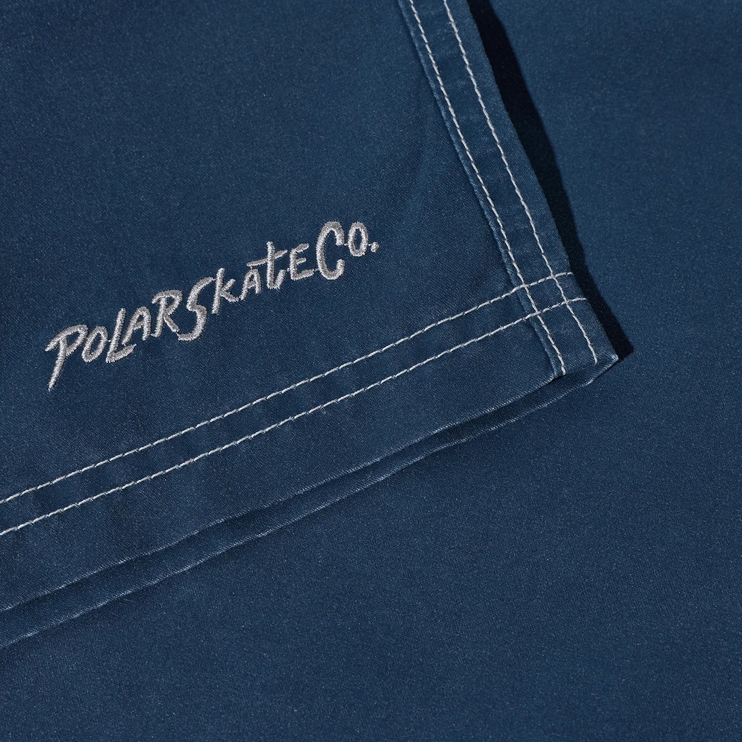 水陸両用可能なPolar Skate Co(ポーラー)のスイムショーツ「ZIGGY SWIM SHORTS」のVINTAGE INDIGOカラーの裾の刺繍デザインの写真