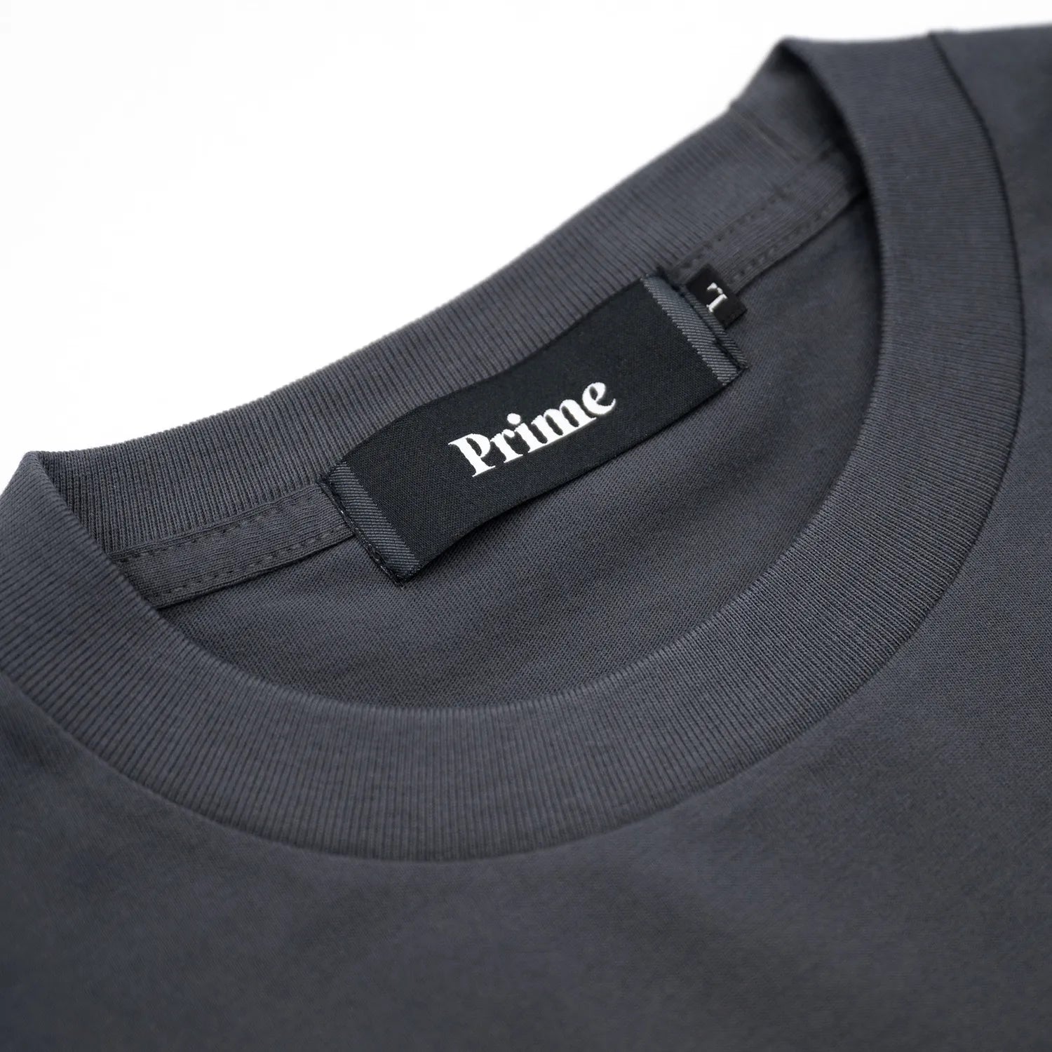 裾にドローコードがついたPrimeのTシャツ「PRIME GALLERY LOGO DRAWCORD TEE」のSUMI BLACKカラーの襟裏のブランドタグ