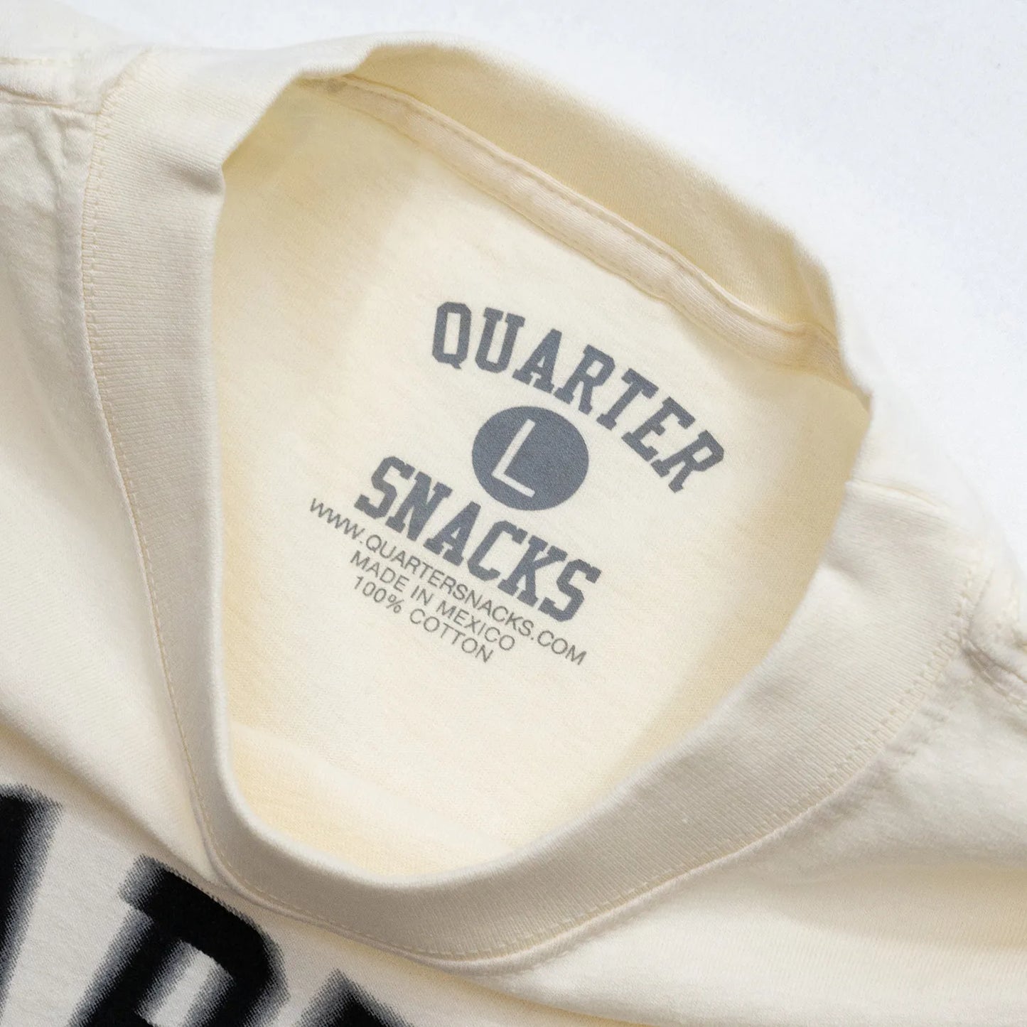 QUARTER SNACKS(クォータースナックス)のCREAMカラーのTシャツ「MOTION ARCH S/S TEE」の襟元の写真