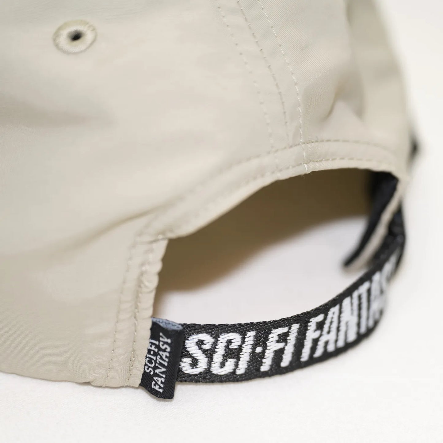 SCI-FI FANTASYのフロントいデザインがプリントされたナイロン製キャップ「EXTREME DESIGN HAT」のTANカラーのアジャスターデザインの写真