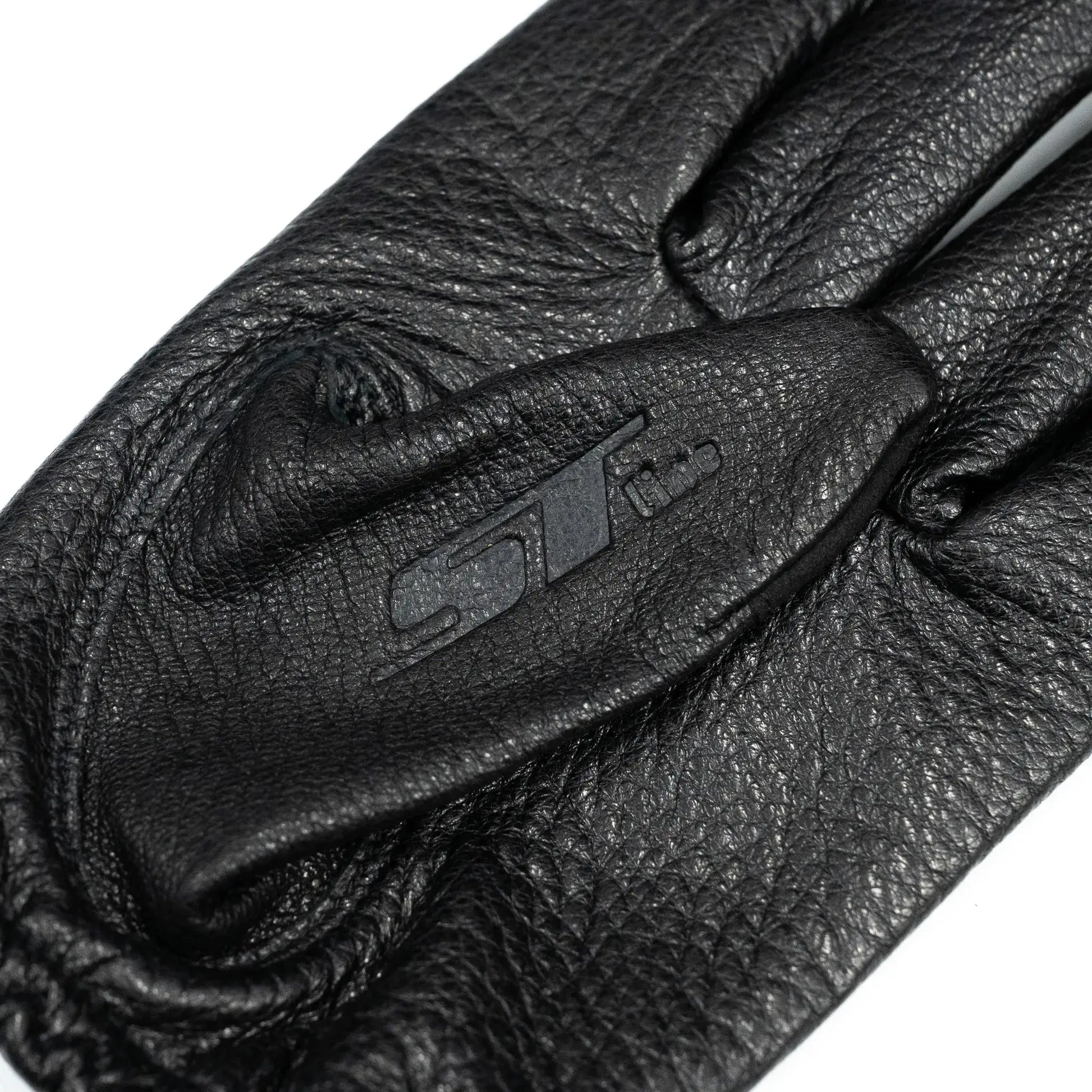 「ST LINE」のやわらかくしなやかなディアスキン（鹿革）を贅沢に使用した、アップデート版ニューデザインモデル「SL-CLASS LEATHER」の親指に型押しされたブランドロゴの写真