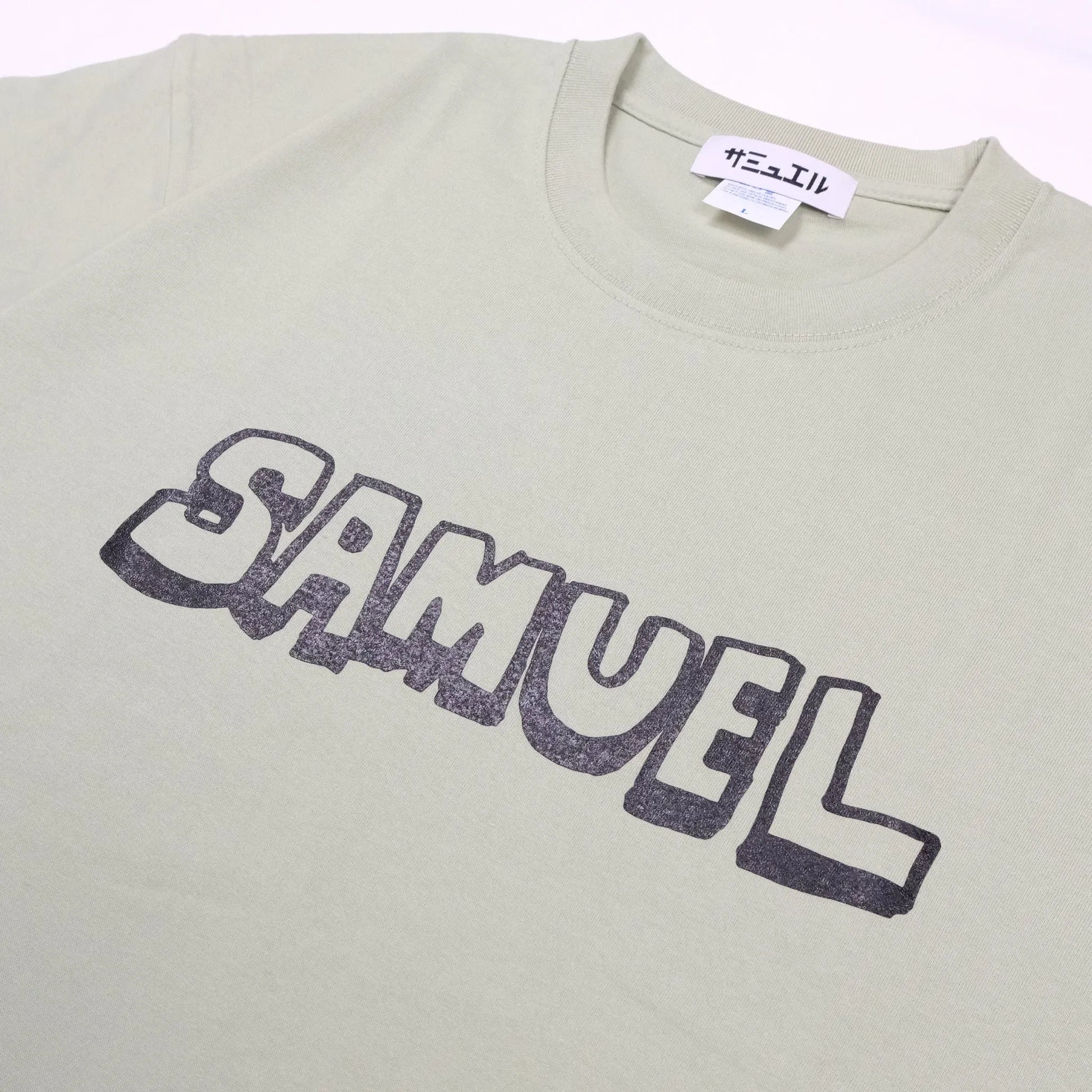 スチャダラパーのANI（アニ）氏とナオヒロック（IIIIINOUT）による「SAMUEL」の定番グラフィックのTシャツ「DAT TEE」のSAGE GREENカラーの正面のメイングラフィック写真