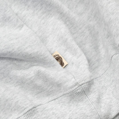 TRIBE WEAR(トライブウェア)の肉厚なフーディー｜パーカー「BASIC HOODIE」のGREYカラーの左脇下のブランドタグ写真