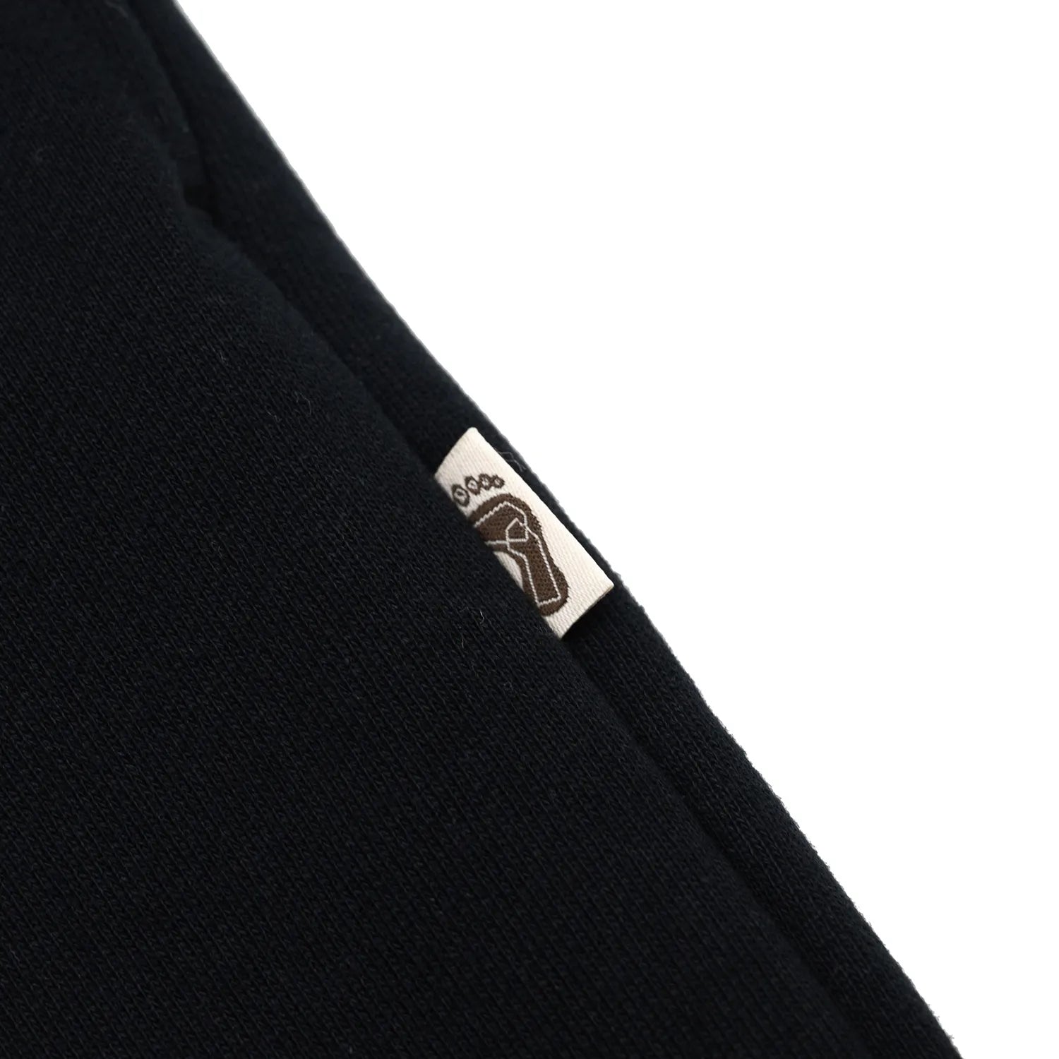 TRIBE WEAR(トライブウェア)のヘビーオンスなパイル生地を使用した「BASIC SWEAT PANTS」のBLACKカラーのサイドピスネームの写真