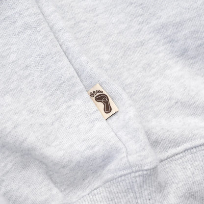 TRIBE WEAR(トライブウェア)の肉厚な生地感とファットなシルエットのクルーネックスエット「BASIC SWEAT CREWNECK」のGREYカラーの左脇下のブランドタグの写真