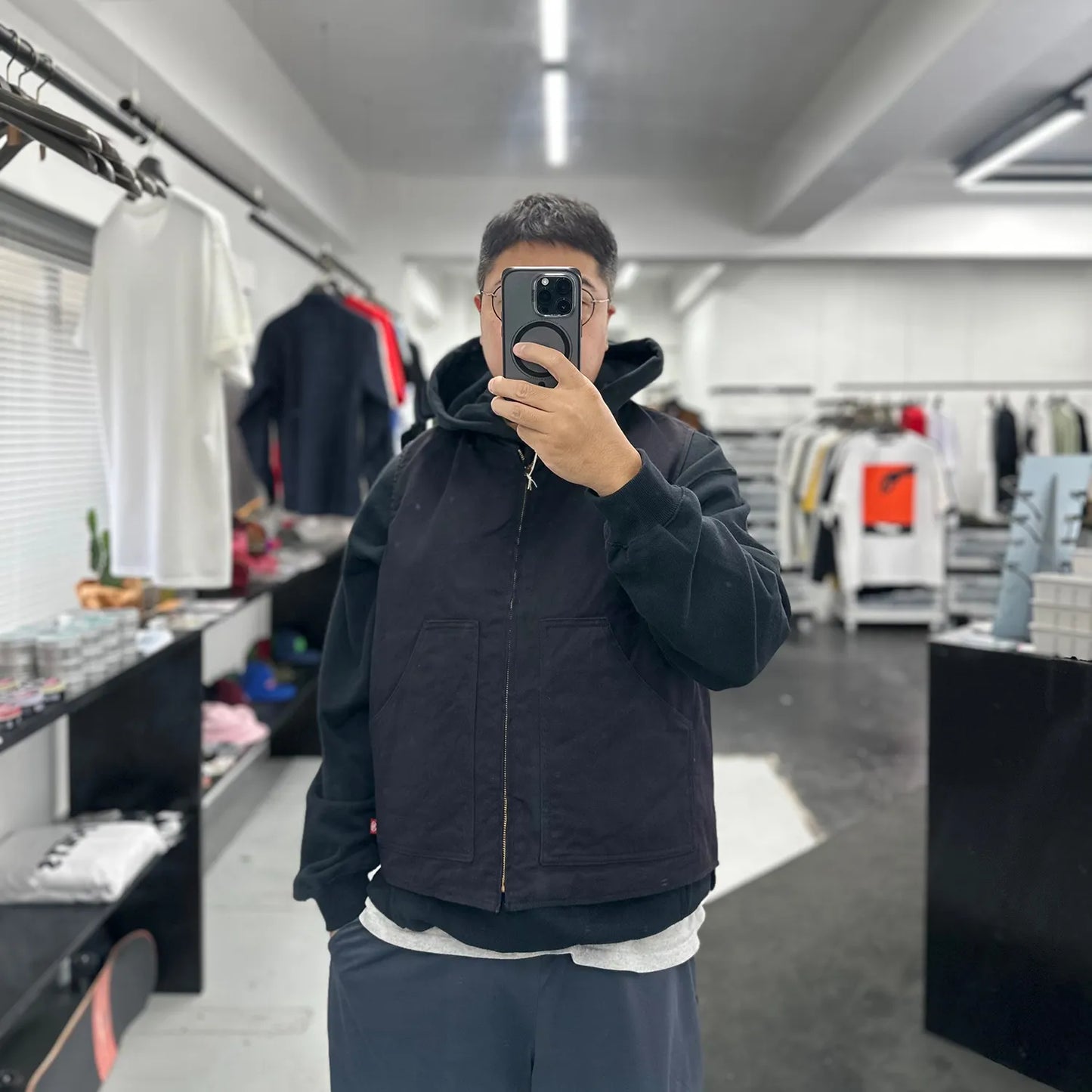 東洋エンタープライズによるTUF-NUT(タフナット)の12.5ozのコットンダック生地を使用した「COTTON DUCK WORK VEST」のBLACKカラーをパーカーの上に着た着用写真