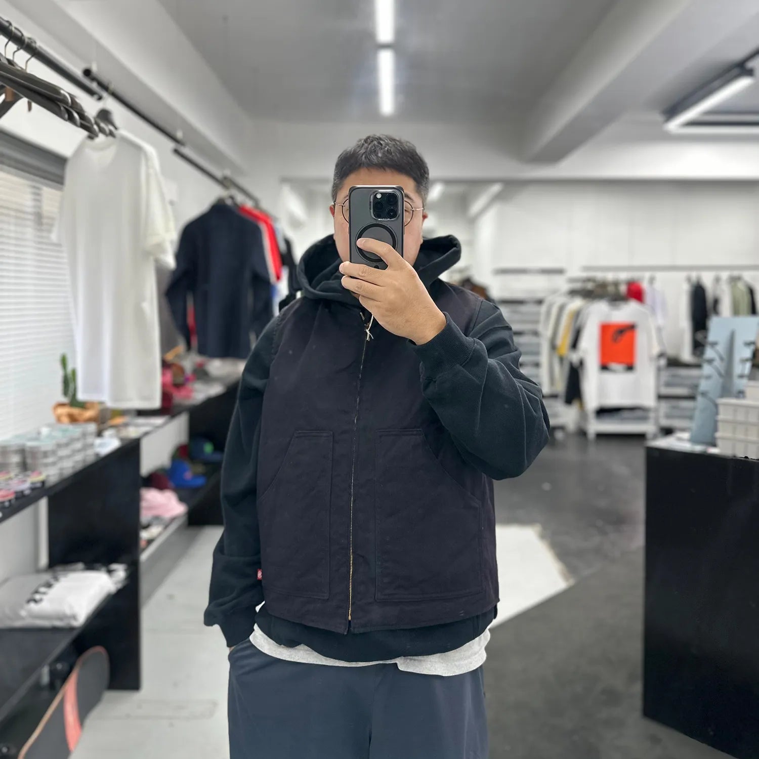 東洋エンタープライズによるTUF-NUT(タフナット)の12.5ozのコットンダック生地を使用した「COTTON DUCK WORK VEST」のBLACKカラーをパーカーの上に着た着用写真