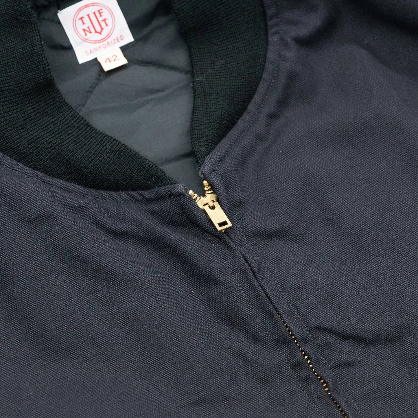 東洋エンタープライズによるTUF-NUT(タフナット)の12.5ozのコットンダック生地を使用した「COTTON DUCK WORK VEST」のBLACKカラーの襟元とジップアップの写真