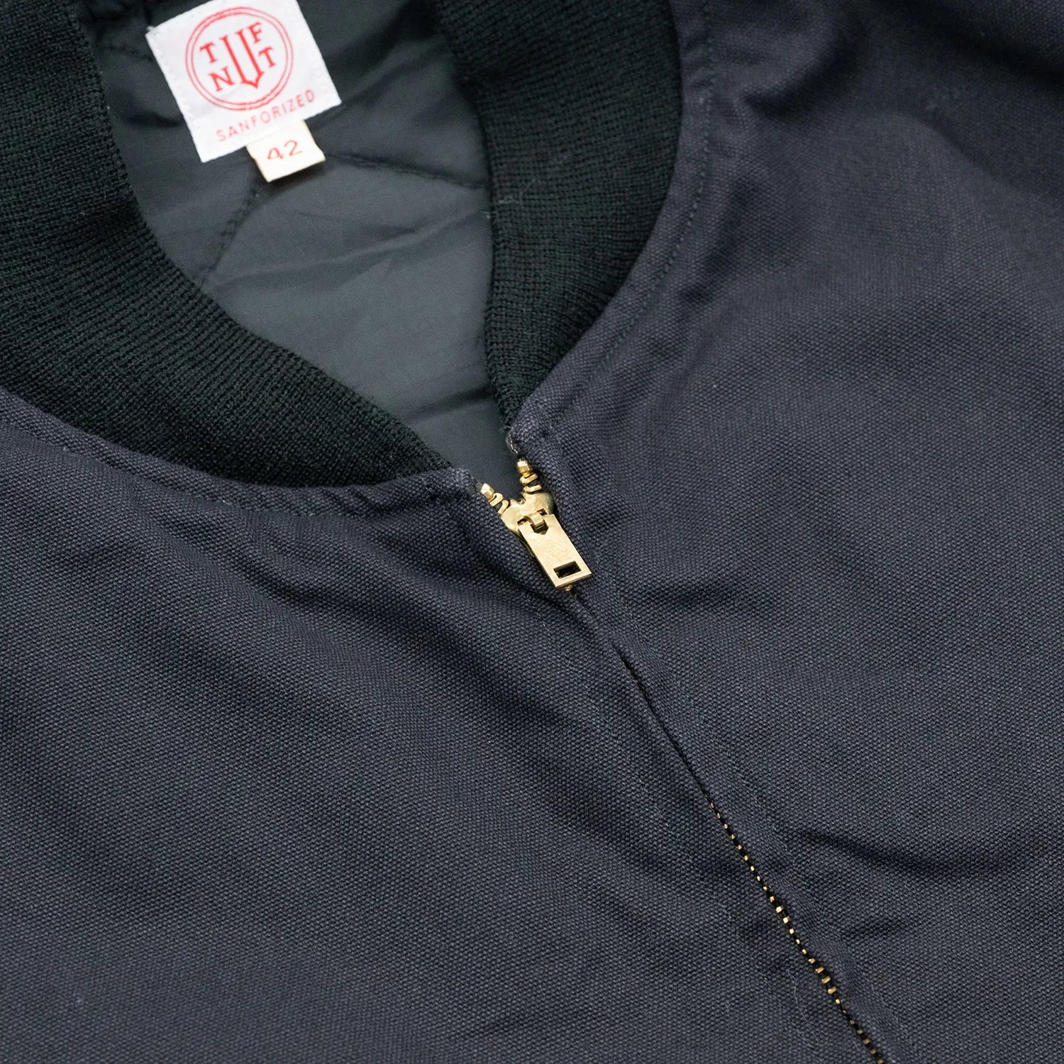 東洋エンタープライズによるTUF-NUT(タフナット)の12.5ozのコットンダック生地を使用した「COTTON DUCK WORK VEST」のBLACKカラーの襟元とジップアップの写真