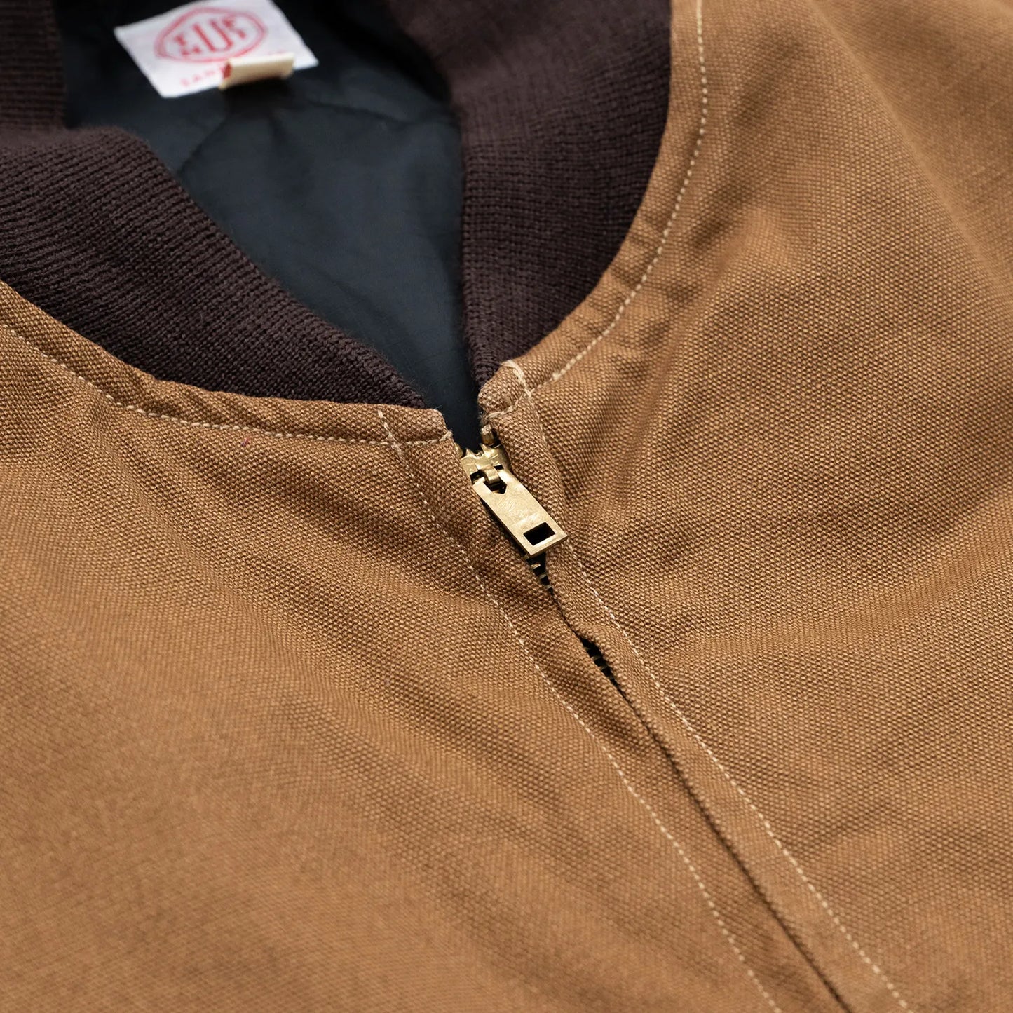 東洋エンタープライズによるTUF-NUT(タフナット)の12.5ozのコットンダック生地を使用した「COTTON DUCK WORK VEST」のCAMELカラーの襟元とジップアップの写真