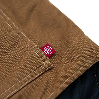 東洋エンタープライズによるTUF-NUT(タフナット)の12.5ozのコットンダック生地を使用した「COTTON DUCK WORK VEST」のCAMELカラーのフロント左ポケット脇のピスネームの写真